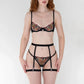 Black tulle underwire scoop neckline bra with warm tone floral embroidery, black tulle thong, regular rise with warm-tone floral embroidery, Black ruched satin over elastic garter with detachable leg bands and back adjustable hook and eye closure