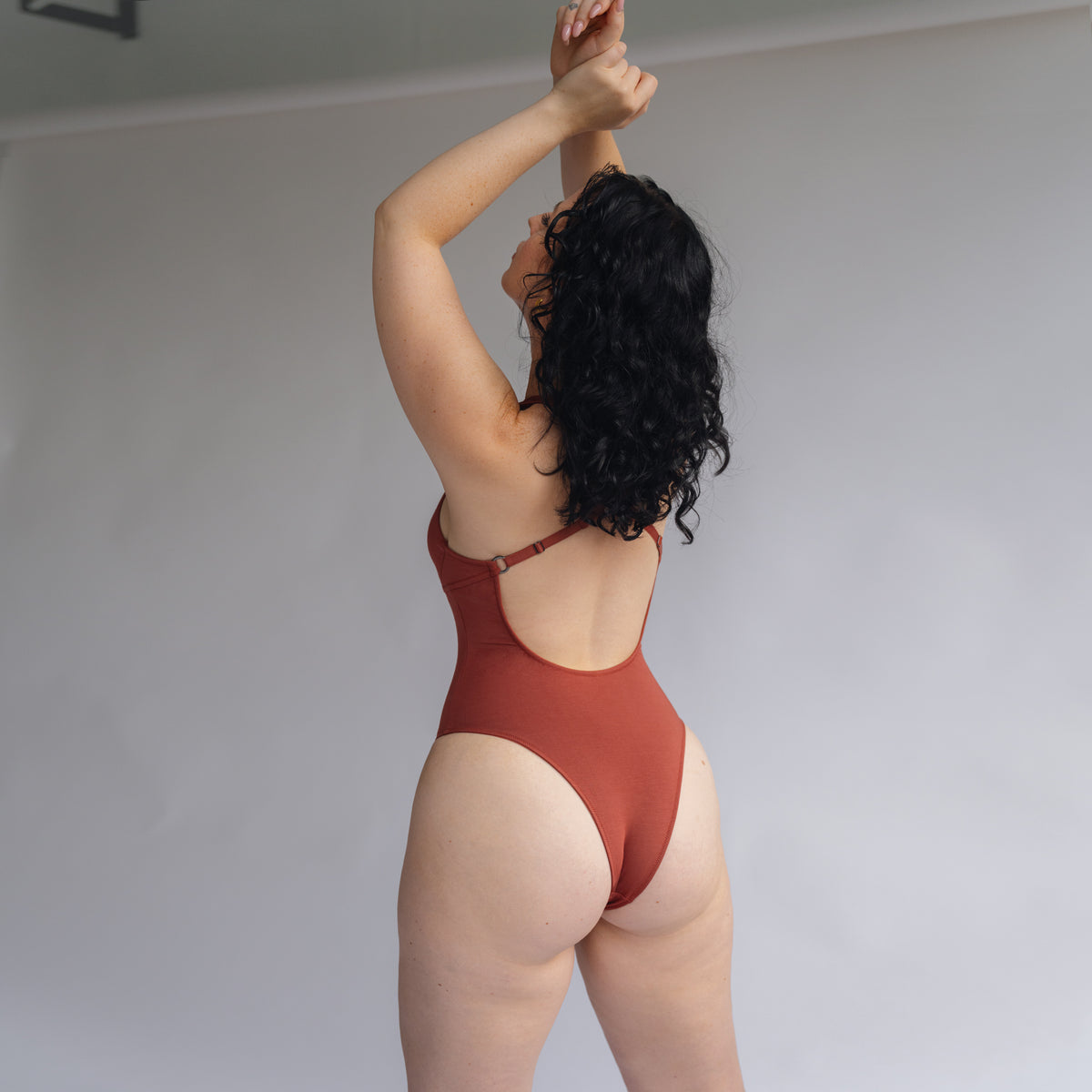 Model wearing a brown Bodysuit with crossed back detail