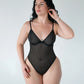 Black opaque on sheer striped microfiber bodysuit with flexible underwire, adjustable straps and back closure with button snap close at gusset