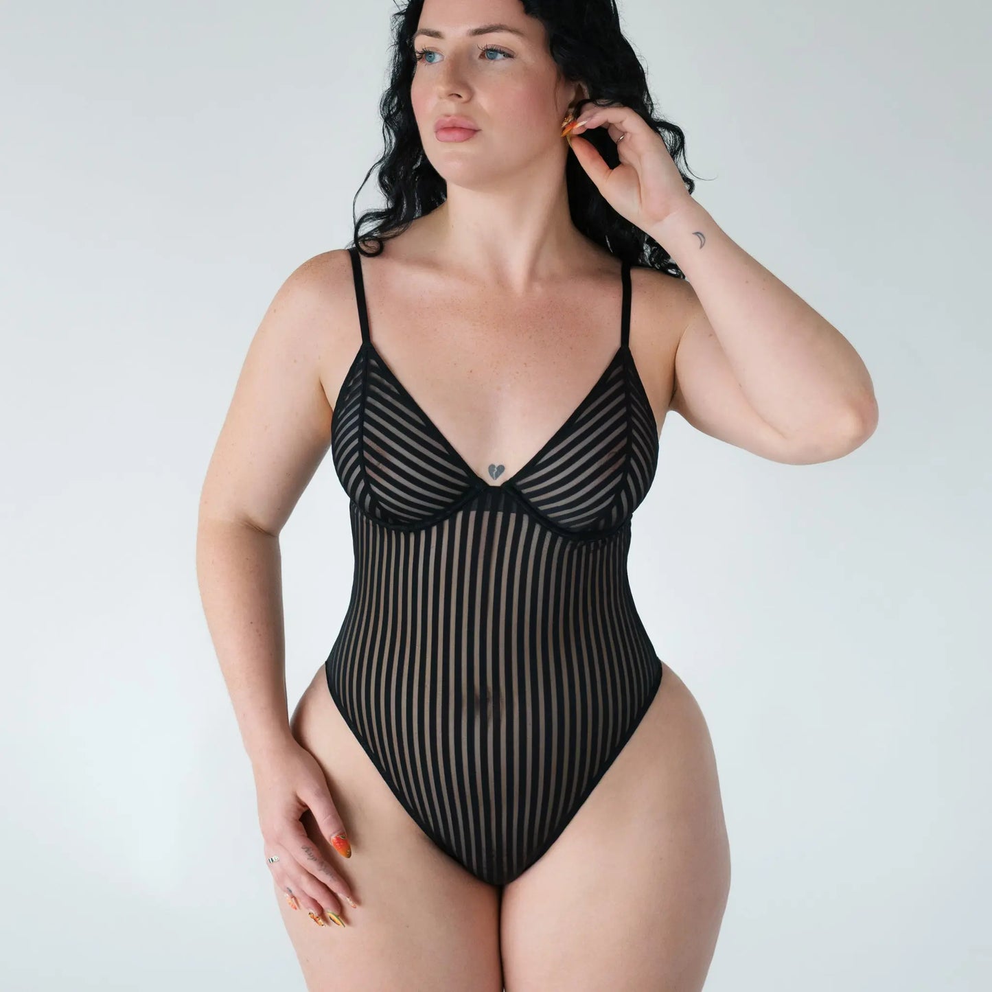 Black opaque on sheer striped microfiber bodysuit with flexible underwire, adjustable straps and back closure with button snap close at gusset