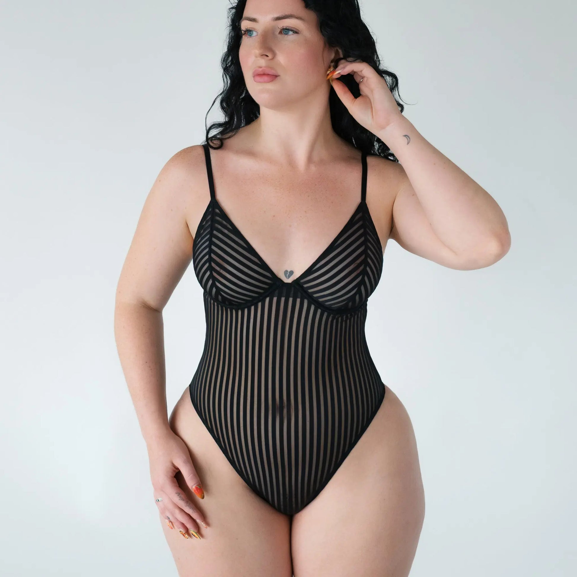 Black opaque on sheer striped microfiber bodysuit with flexible underwire, adjustable straps and back closure with button snap close at gusset