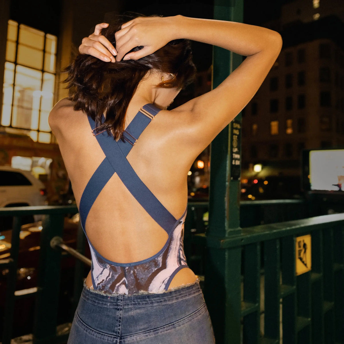 Blue abstract print mesh bodysuit with plunge neckline and criss cross straps in back and button snap closure in gusset