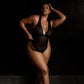 Black opaque on sheer striped microfiber bodysuit with plunge neckline fully adjustable straps criss crossed in back with snap close gusset