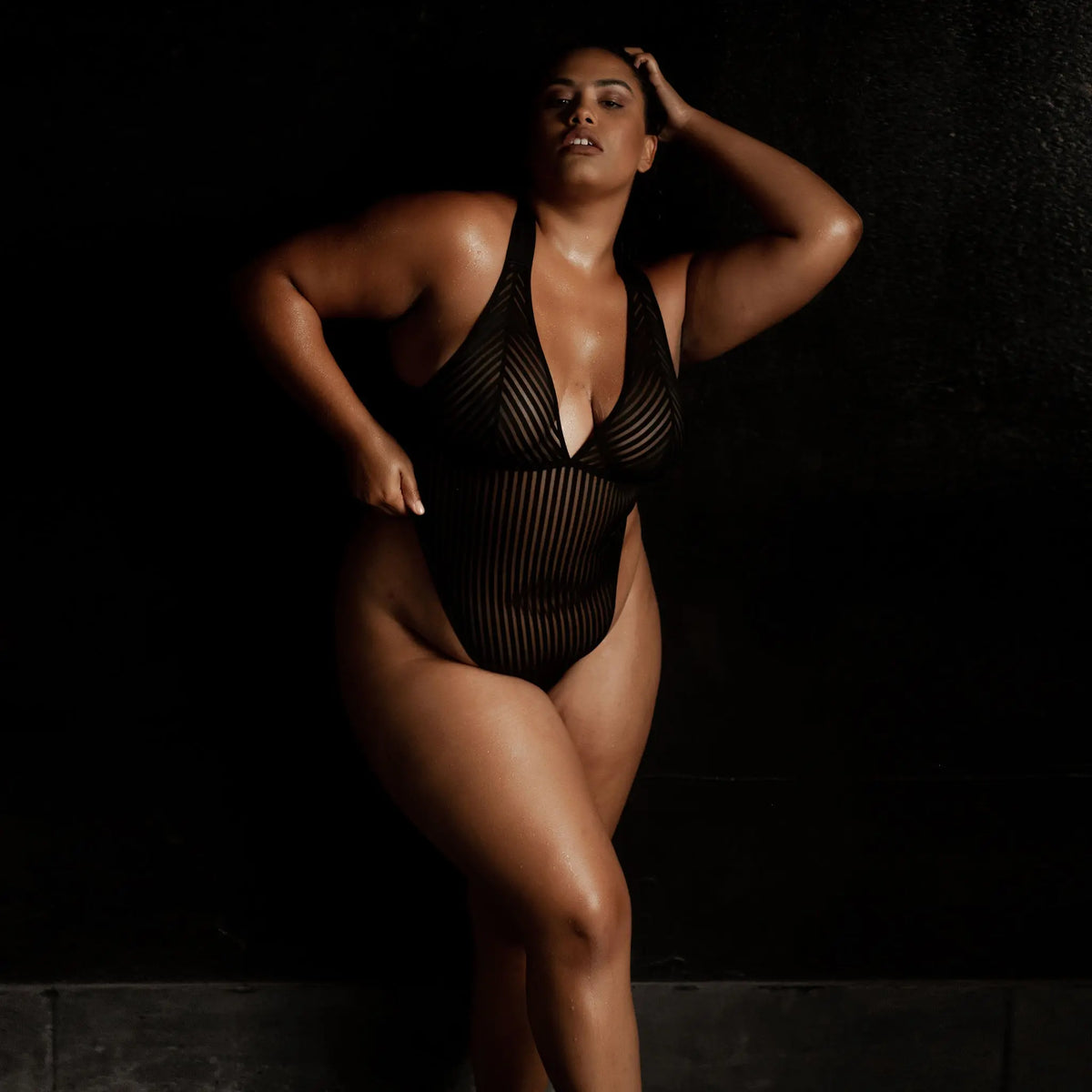 Black opaque on sheer striped microfiber bodysuit with plunge neckline fully adjustable straps criss crossed in back with snap close gusset